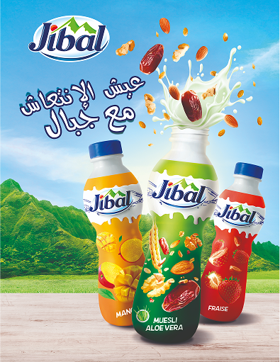 Three bottles of Jibal flavored drinks including mango, muesli aloe vera, and strawberry flavors with nuts and fruits splash against a mountain landscape background.